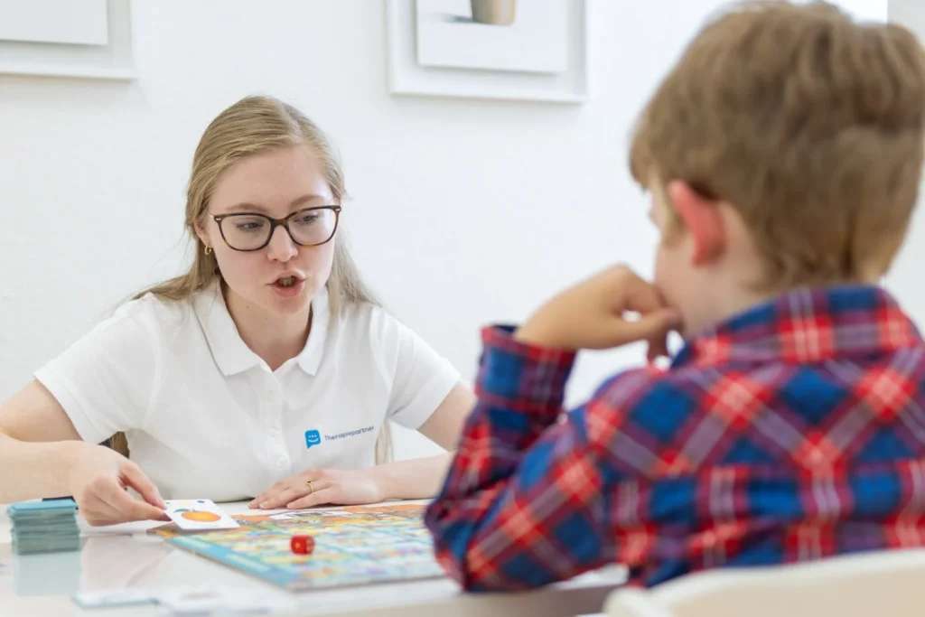 Logopädin während einer Therapiesitzung mit einem Kind bei Therapiepartner